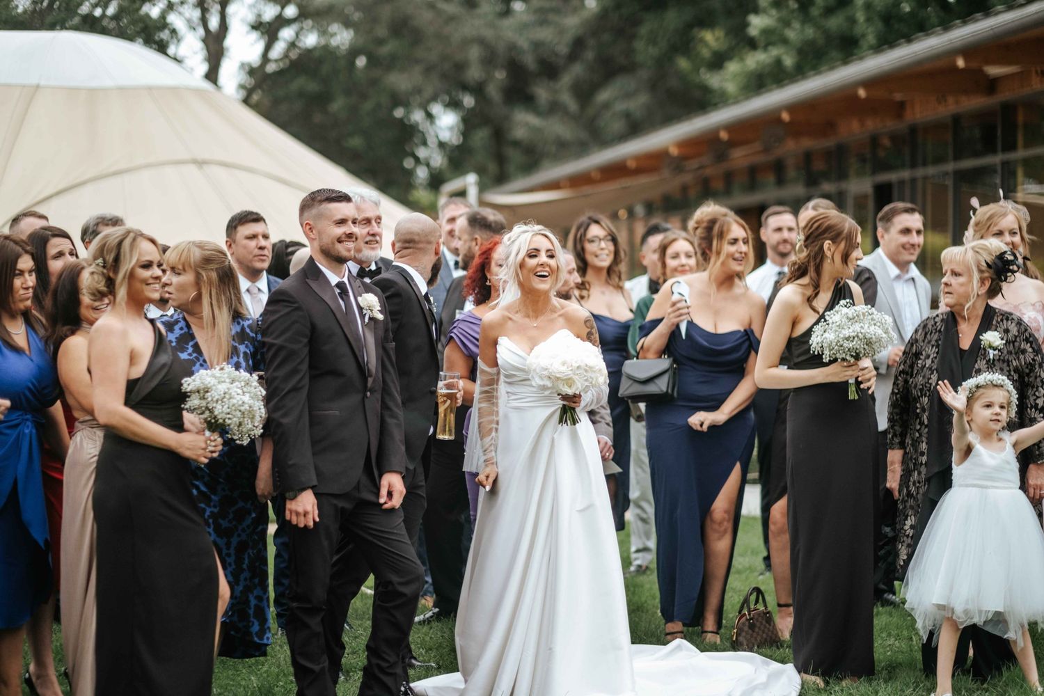 Bride and Groom in Thorpe Garden with all their wedding guests