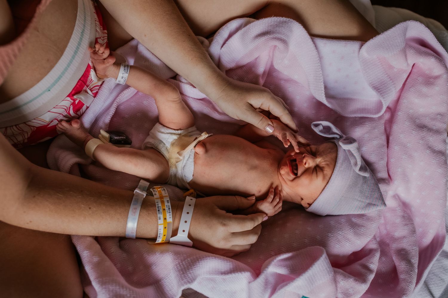 Close-up details of delicate pink dresses and bows during a special occasion.