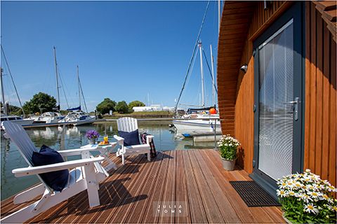 Marina deck with Adirondack chairs overlooking boats and calm water.