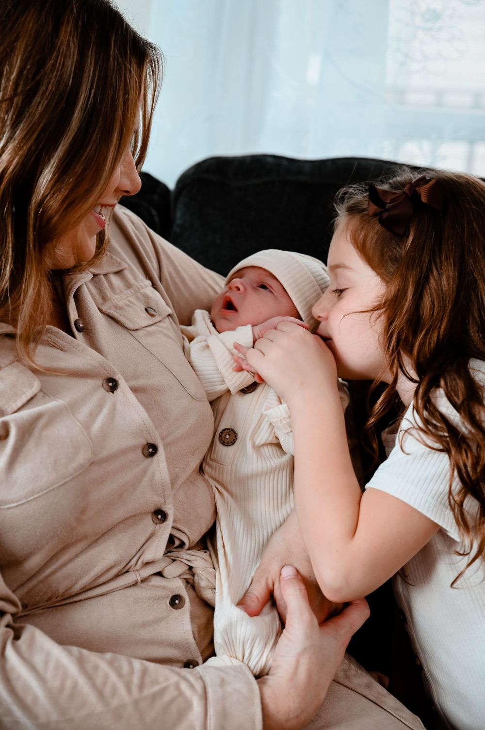 Tender family moments shared on couch in natural window light.
