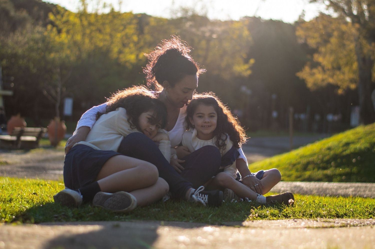 People relaxing on grass during golden hour in a park setting.