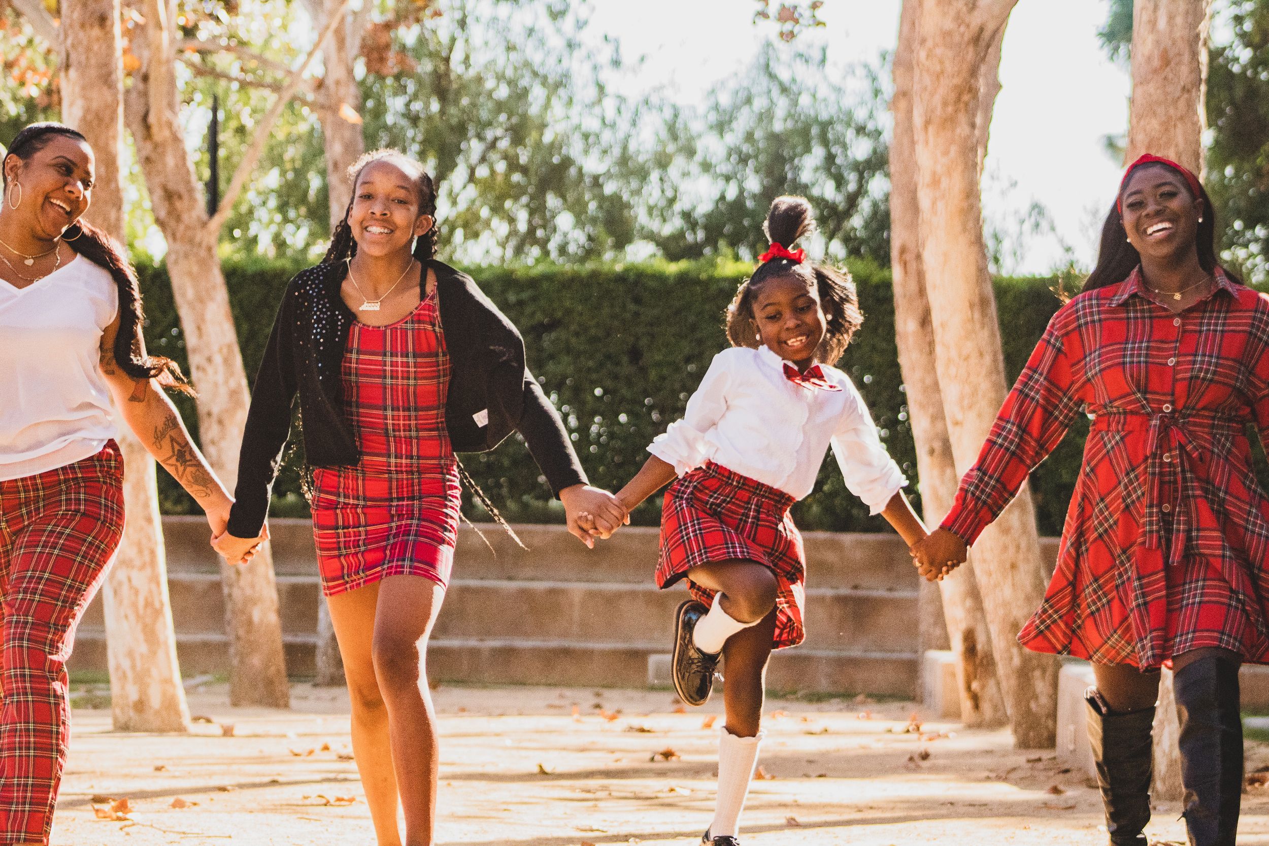 Family wearing matching red plaid outfits walking together outdoors.