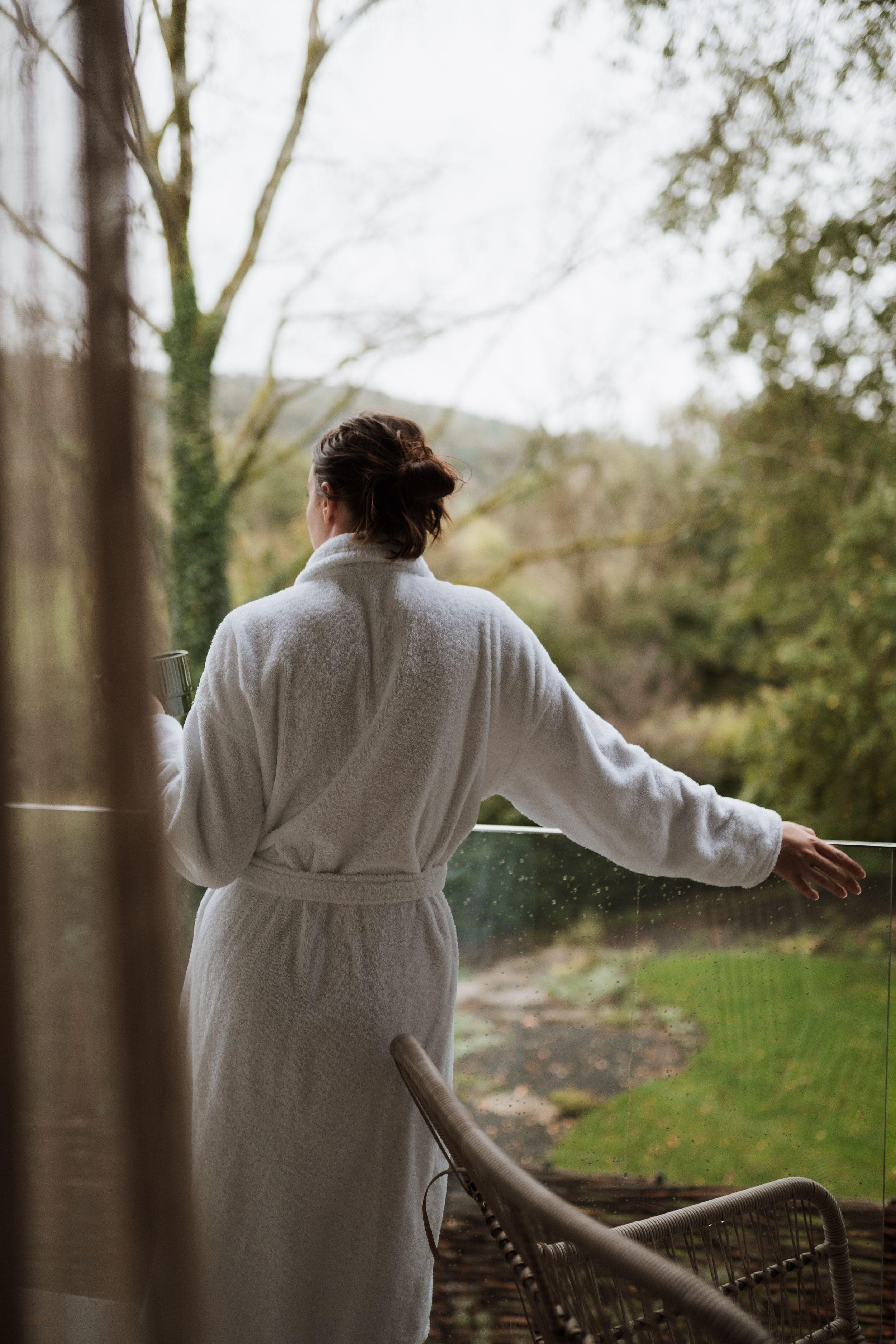 woman wearing bathroom, looking out onto the Lake District from the balcony at rothay manor