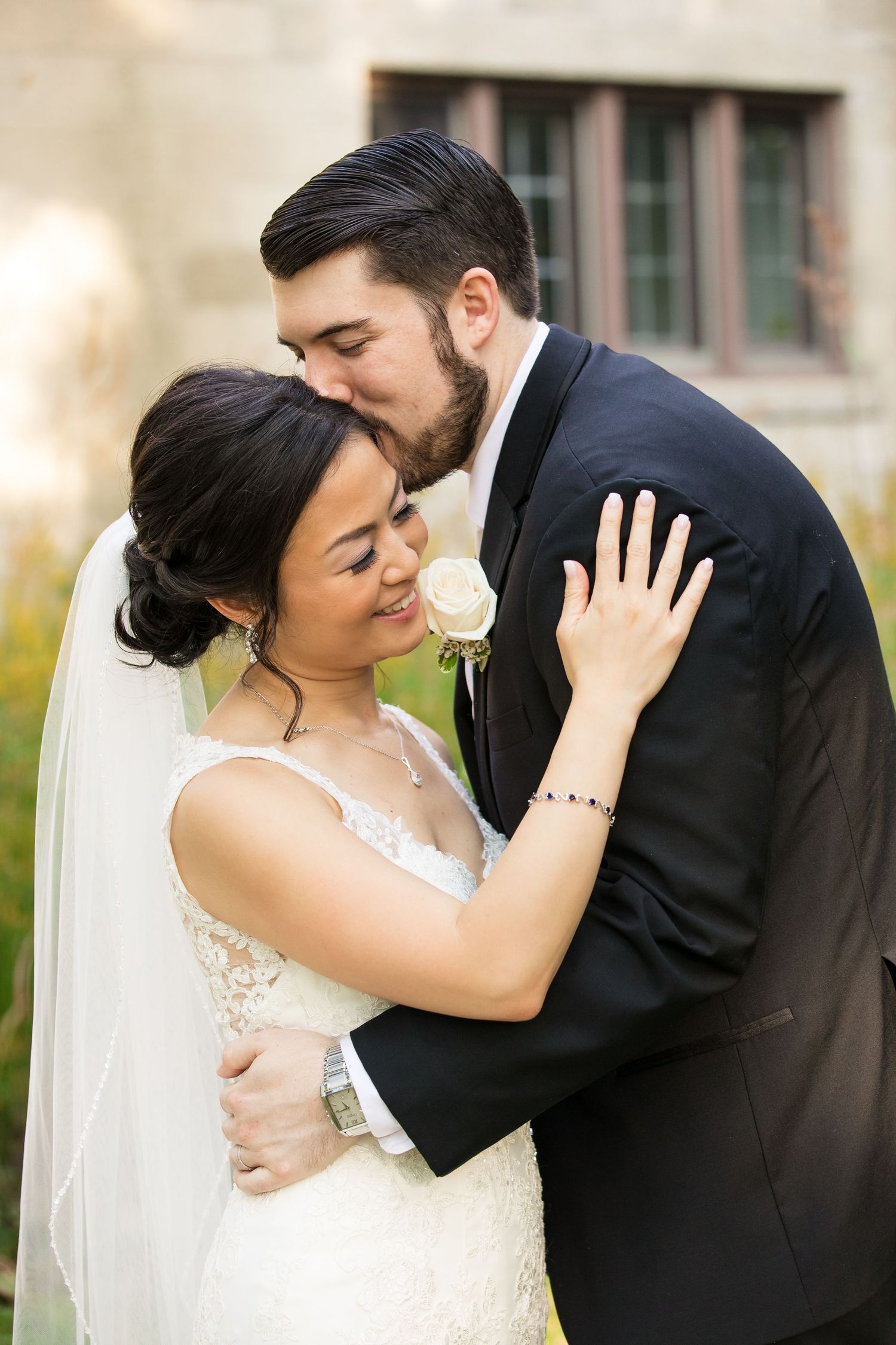 Romantic wedding portrait showing intimate moment between couple with soft natural lighting.