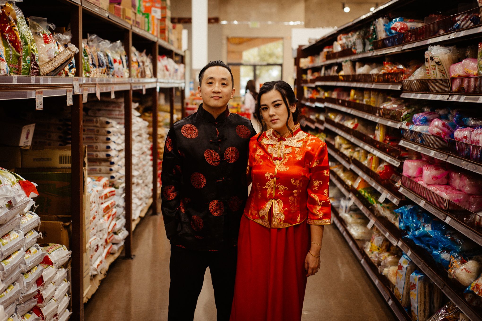 Playful engagement session in grocery store with couple in red outfits.