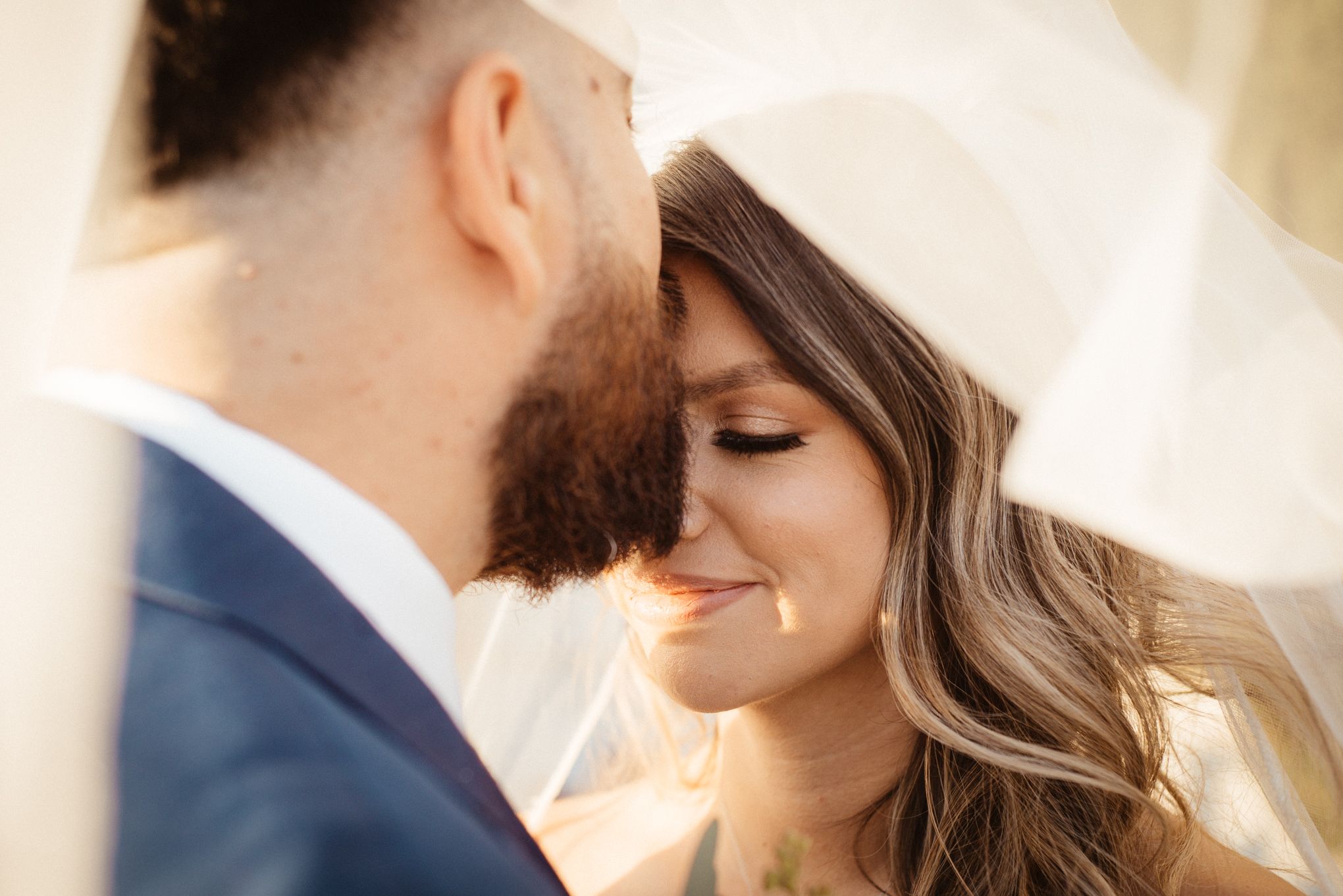 Intimate close-up portrait of couple during romantic wedding moment.