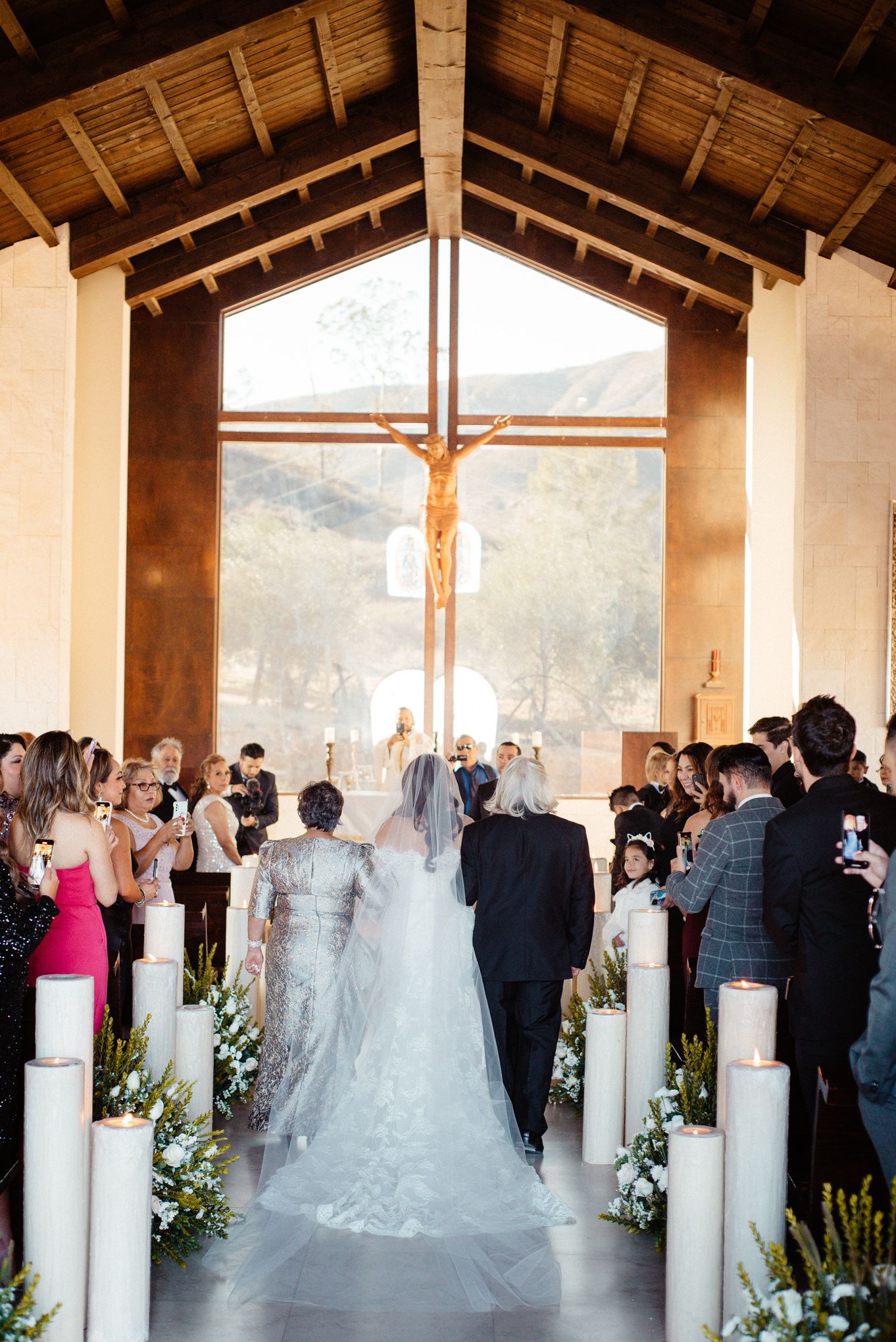 Wedding ceremony in rustic venue with exposed wooden beams and mountain views.
