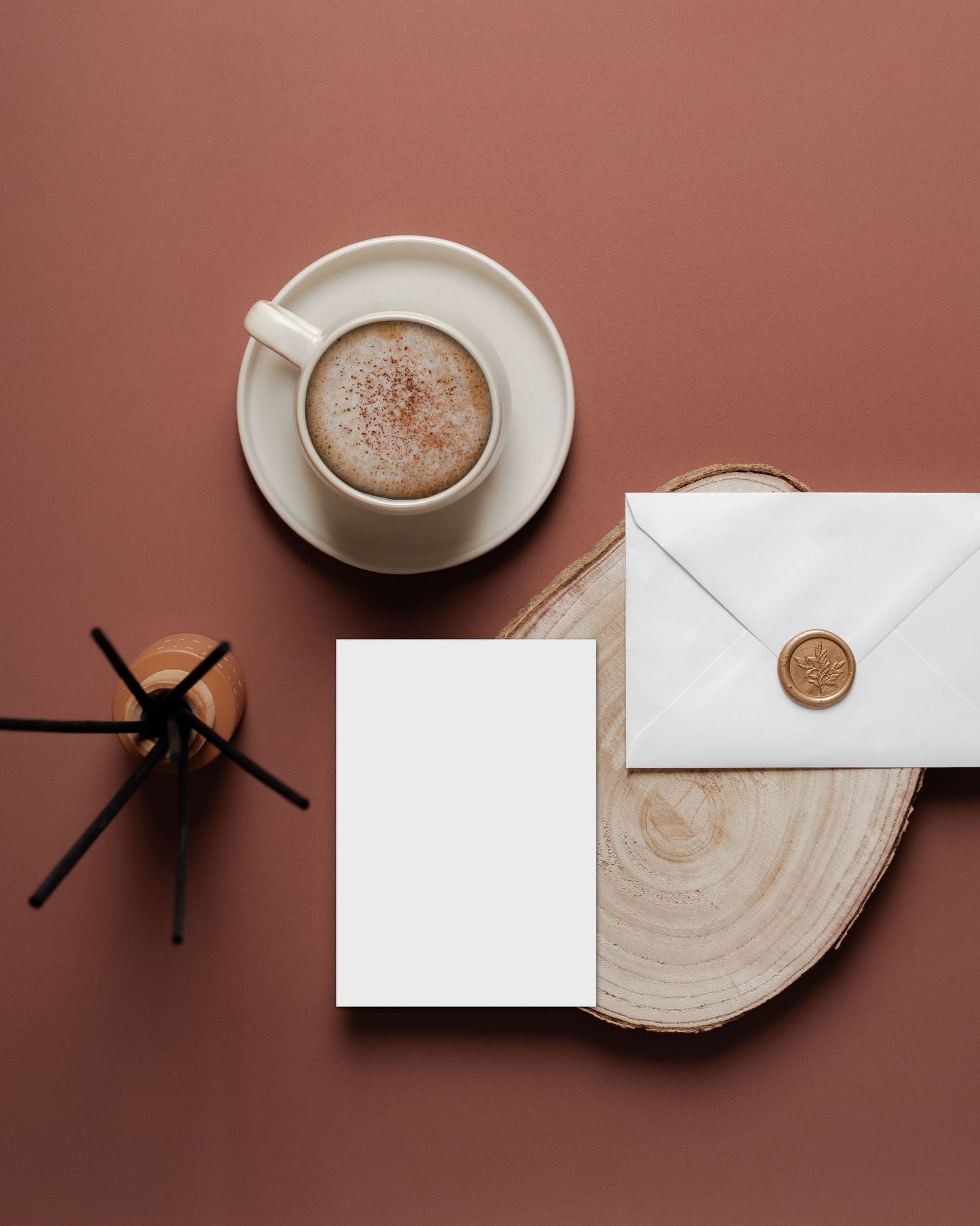 card invite mock-up with envelope, coffee, reed diffuser, muted red backdrop, stylish stock photos for designers