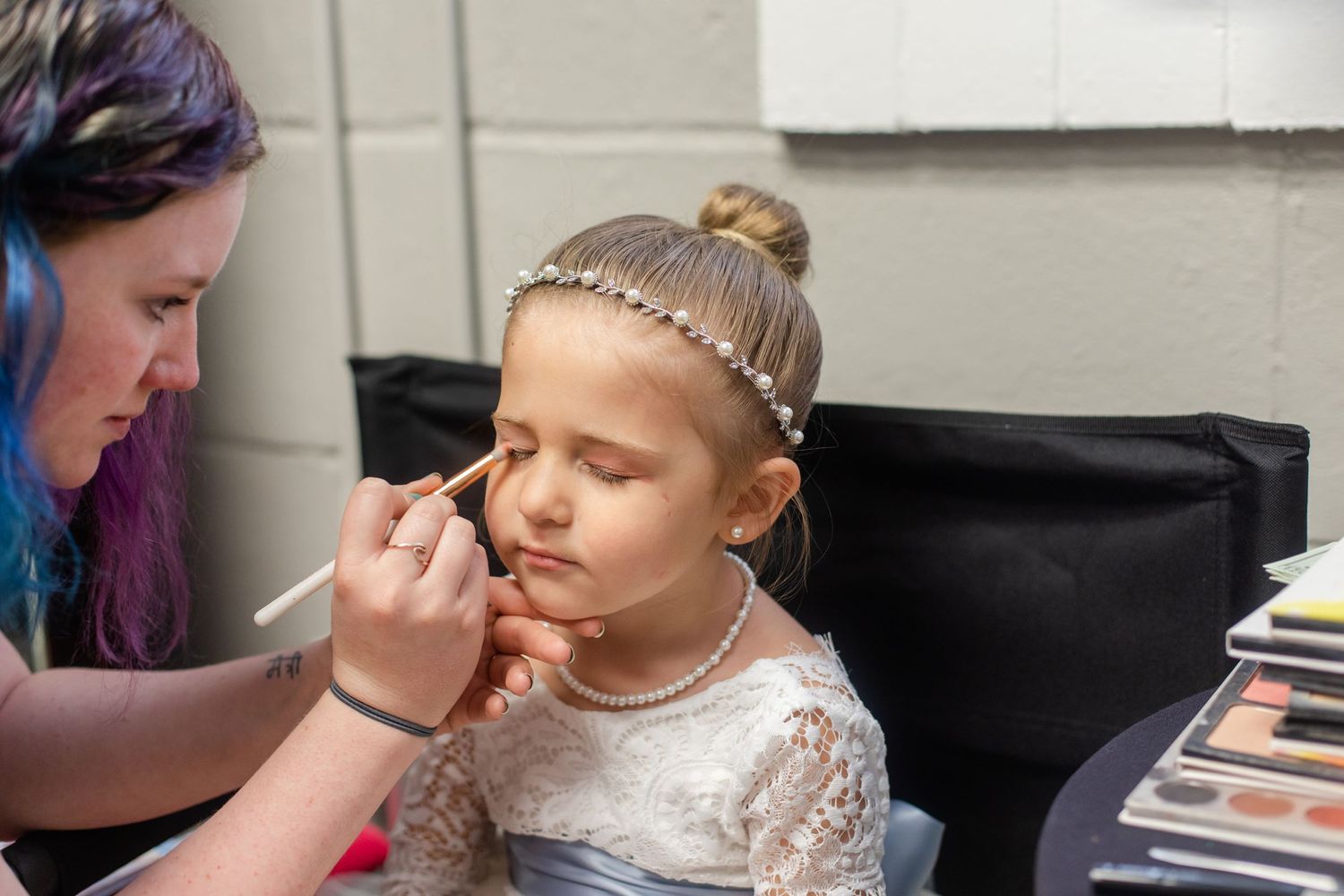 Professional makeup artist applying cosmetics in preparation for special event.