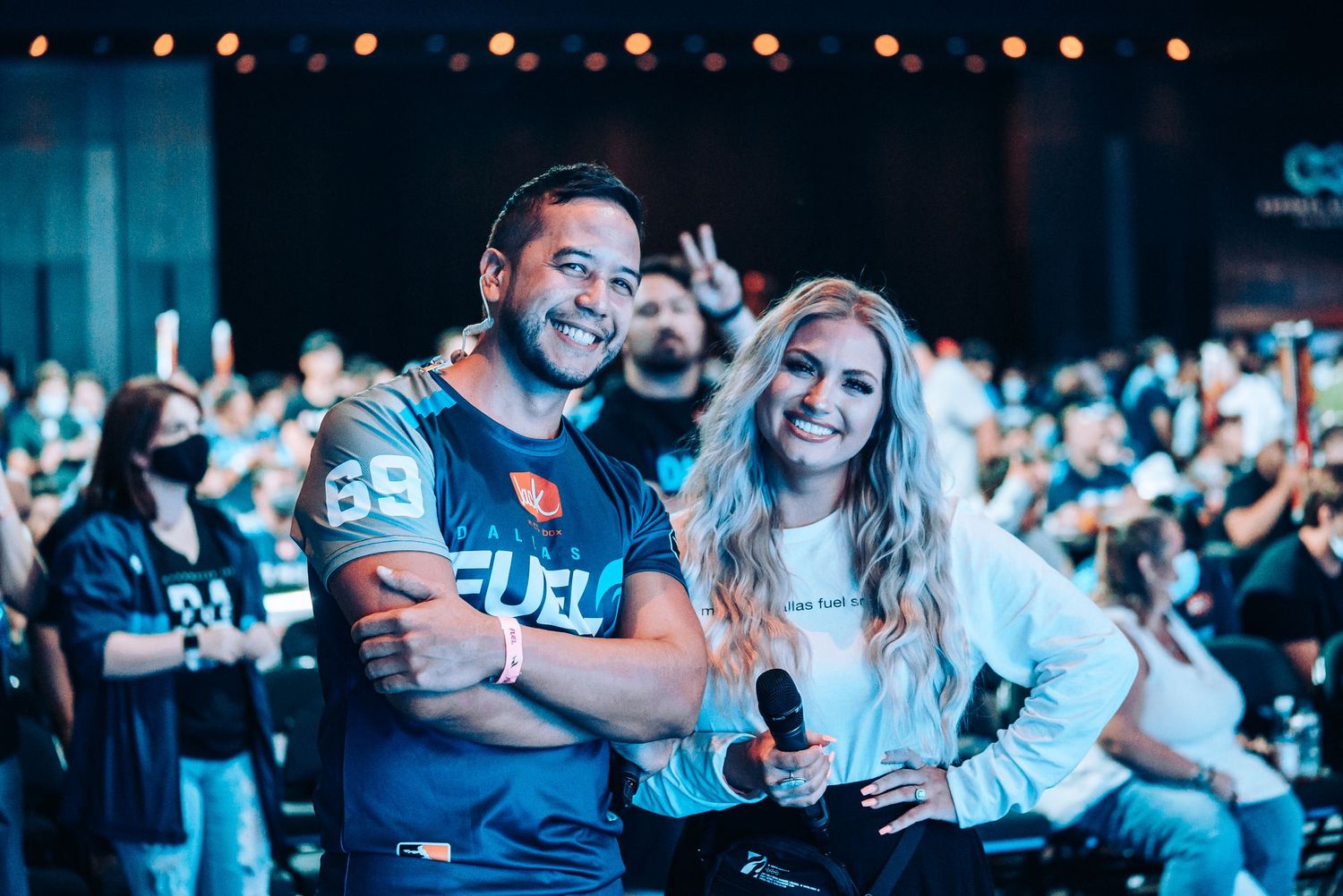 Crowd enjoying esports event with blue lighting and bokeh effects.