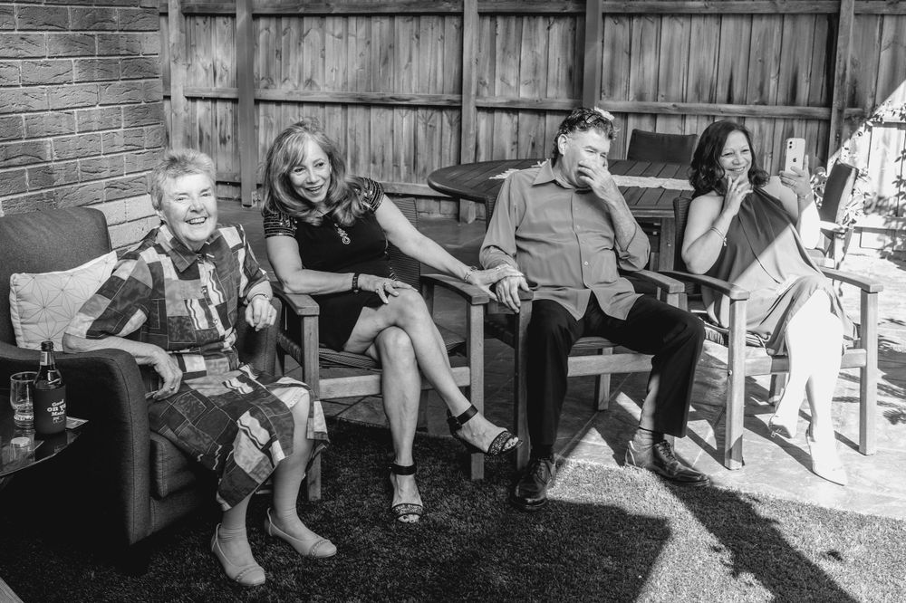 elopement guests relaxing on porch during backyard ceremony