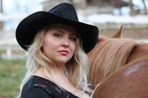 Western portrait featuring black hat and lace against a winter background.