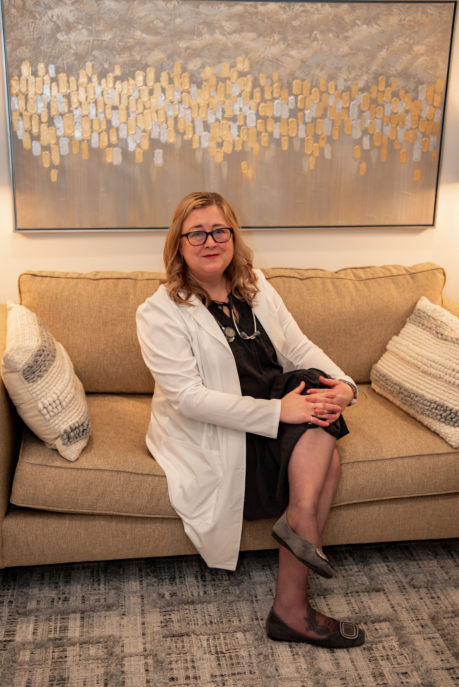 woman physician sitting on couch in office with white coat rebecca byard