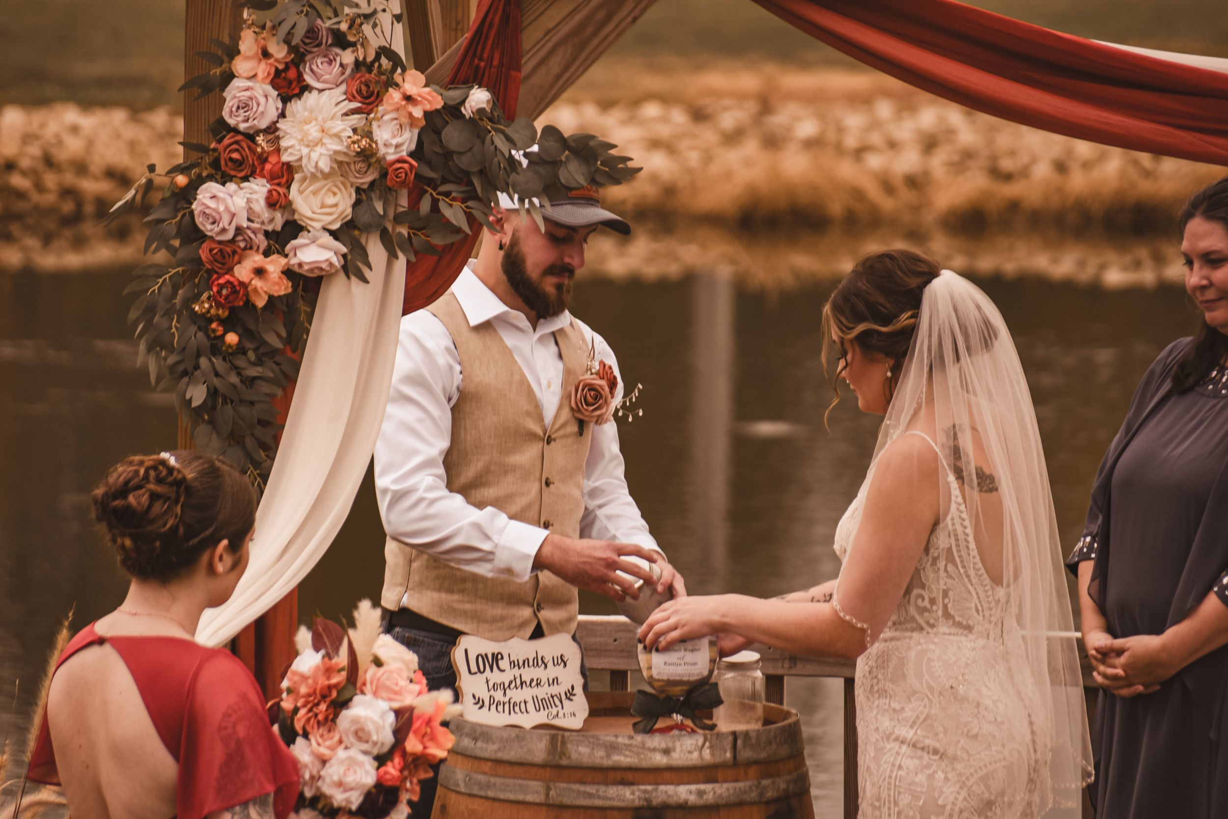 Wedding ceremony with floral decorations and unity ritual around rustic barrel.