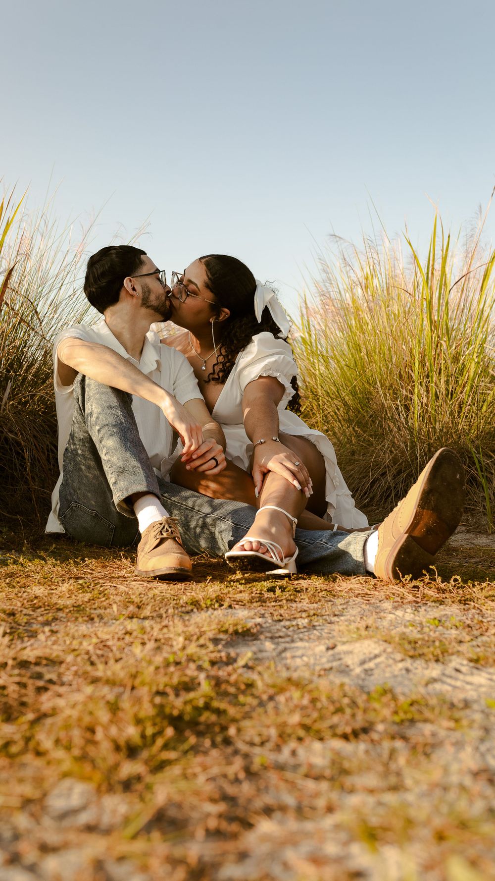 couple kissing with teeth in a high grass field