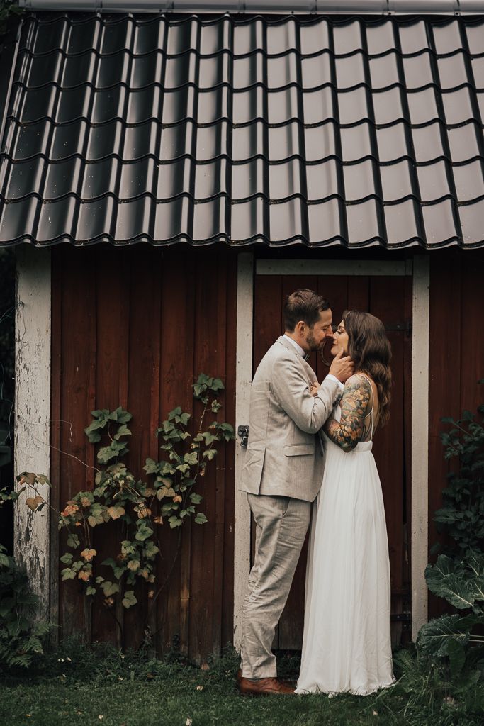 Brudparet framför sin gamla bod. Bröllopsfotografering i Eskilstuna.