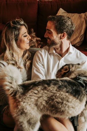 Intimate couple sharing tender moments while lying down in soft romantic lighting.