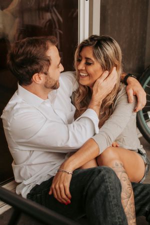 An intimate couple sharing a tender moment while sitting together indoors.