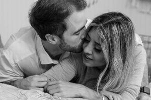 A romantic black and white photo of a couple sharing an intimate moment.