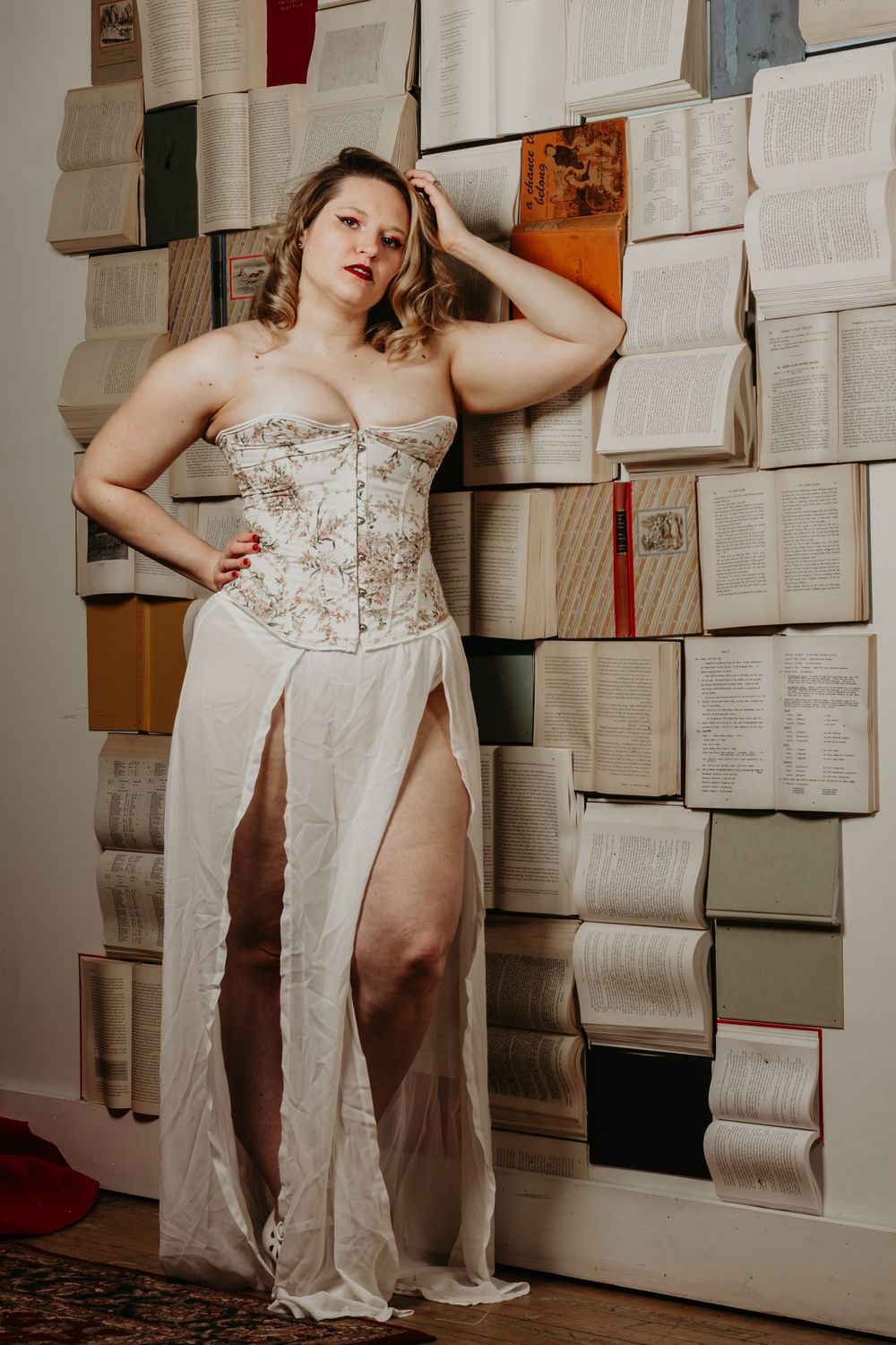 Vintage-style photoshoot with book wall backdrop and classic styling.