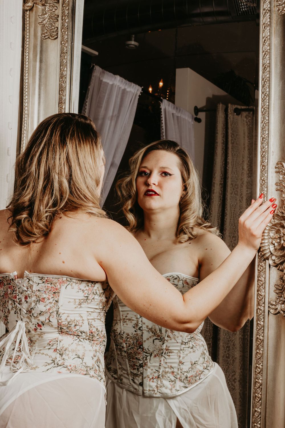 Elegant vintage mirror photoshoot with ornate frame and soft lighting.