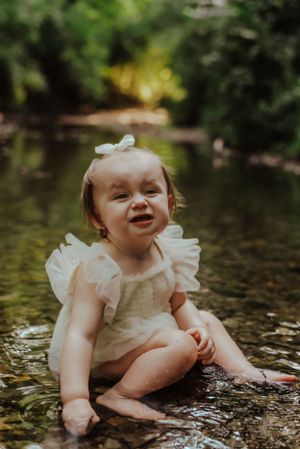 a small toddler sitting in a creek