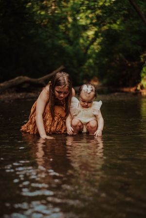two little girls playing in a creek