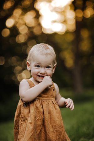 a toddler girl in an orange dress