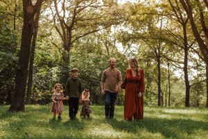 a family of 5 walks through the grass