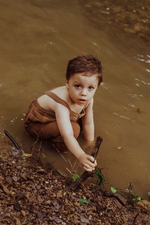 a little boy playing in a creek