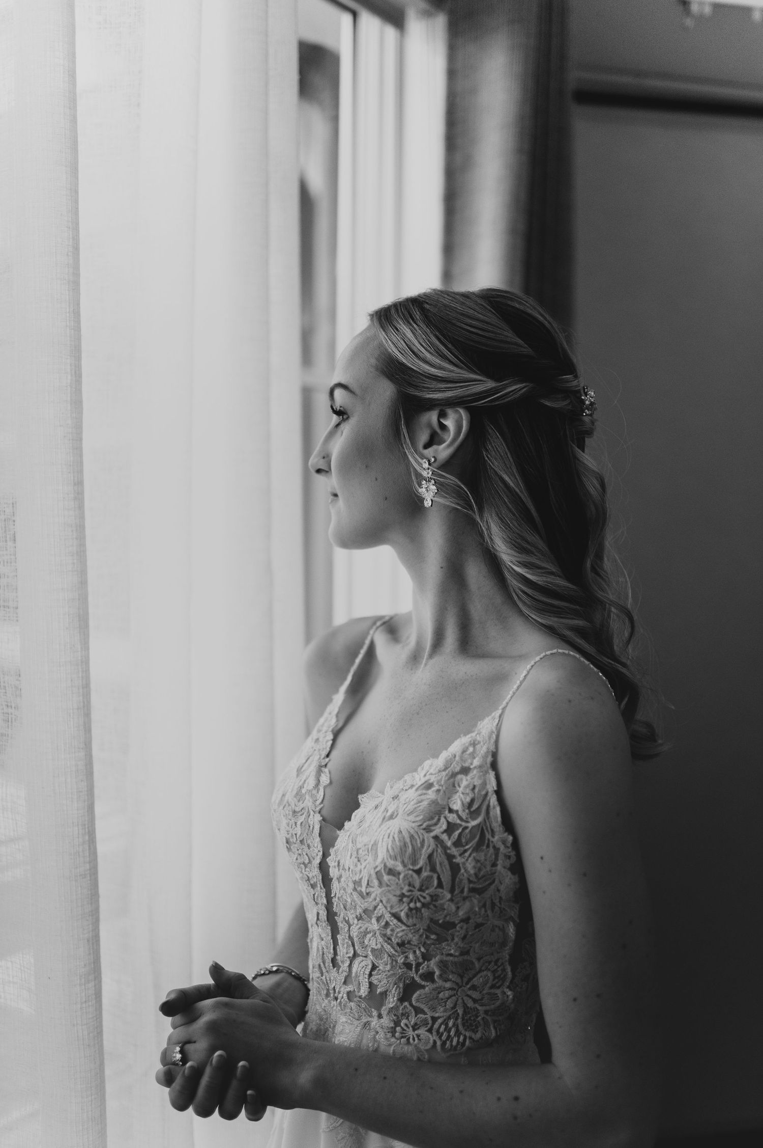 Side profile of person in lace dress against bright window light.