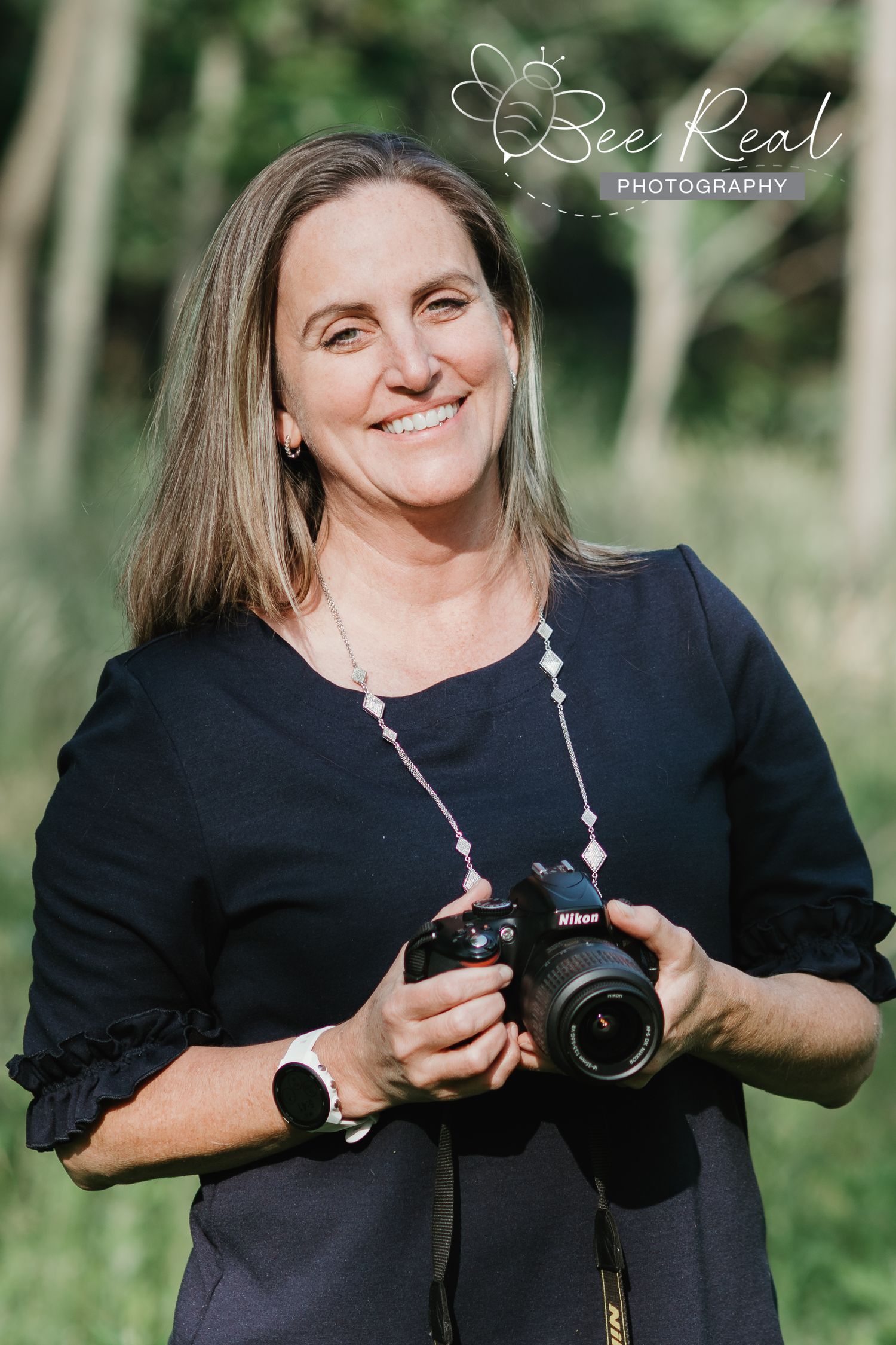 Photographer holding professional camera outdoors in natural lighting.