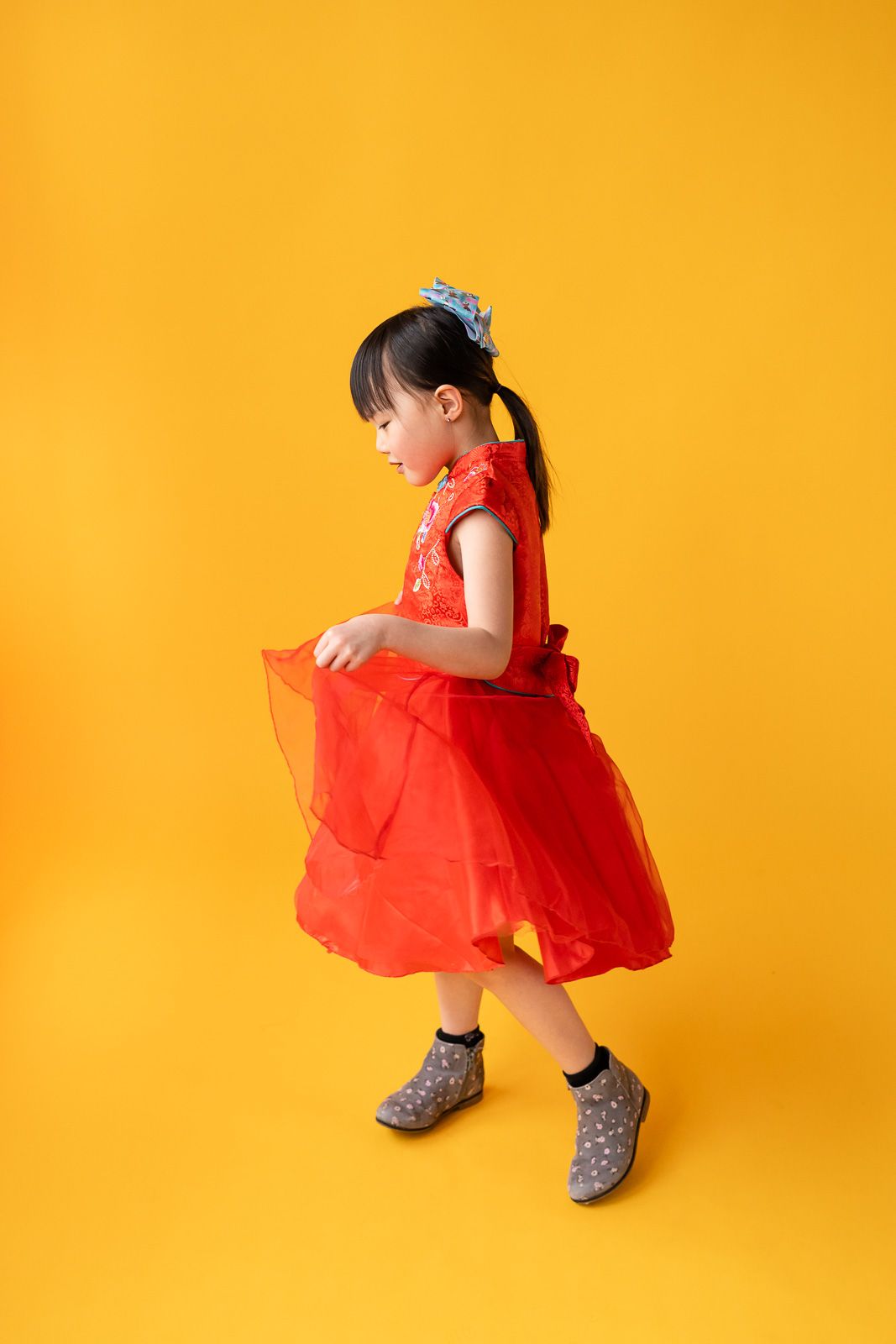 Girl twirling in a red dress at a studio in Seattle