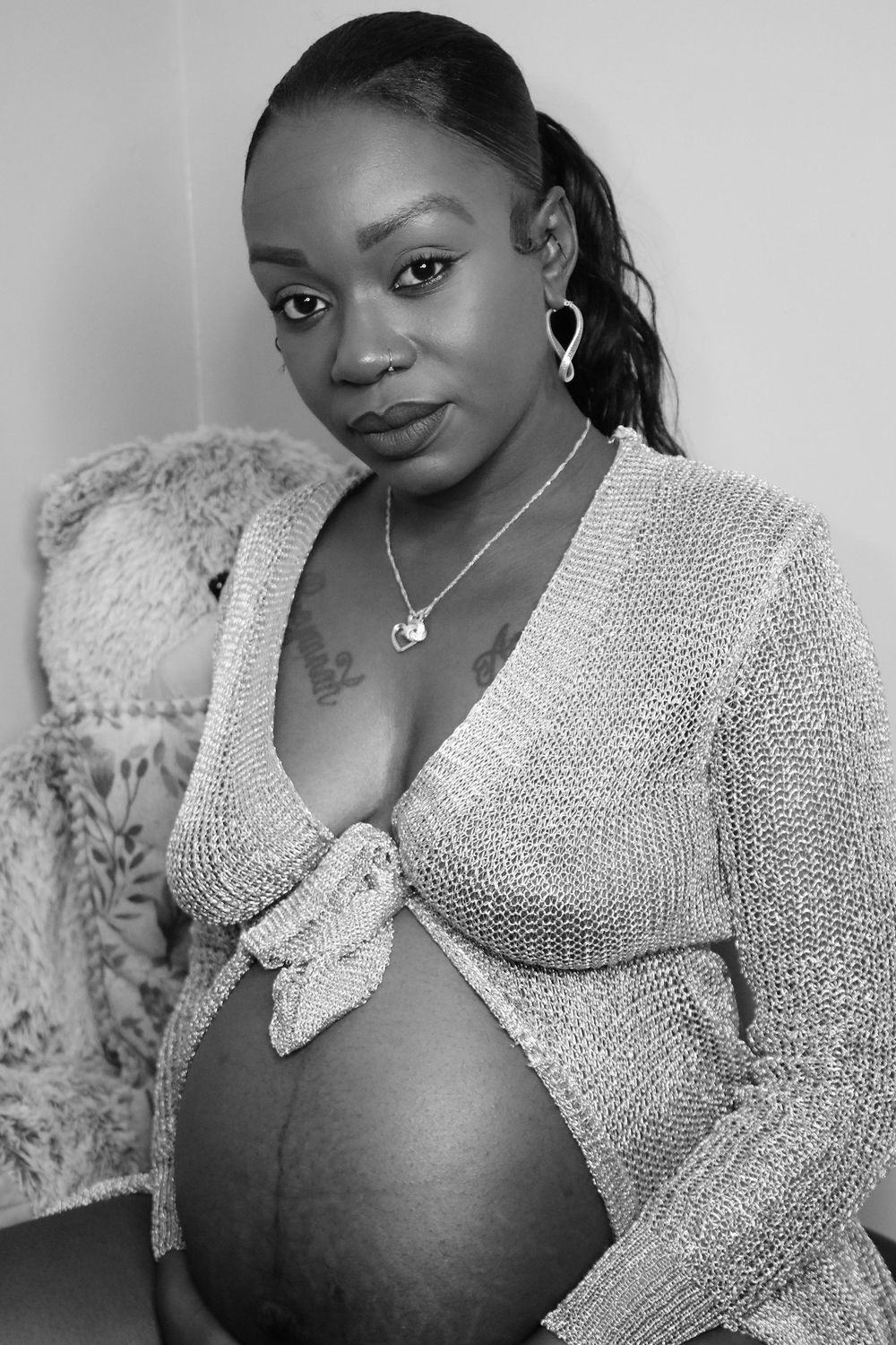 Elegant maternity portrait with woman wearing cream knitted cardigan.