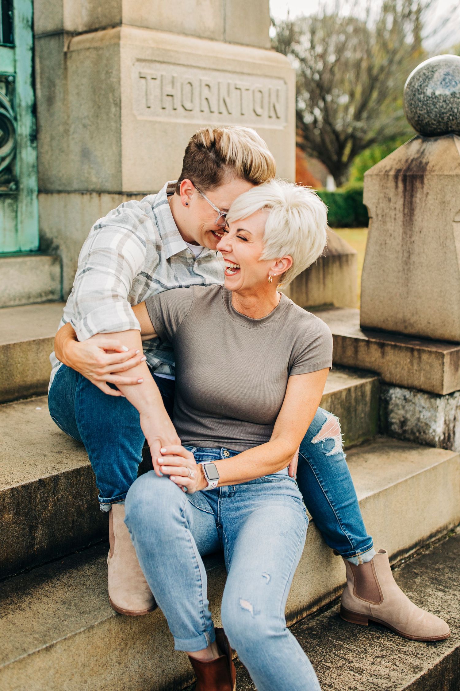Candid laughing moment on stone steps near Thornton building entrance.