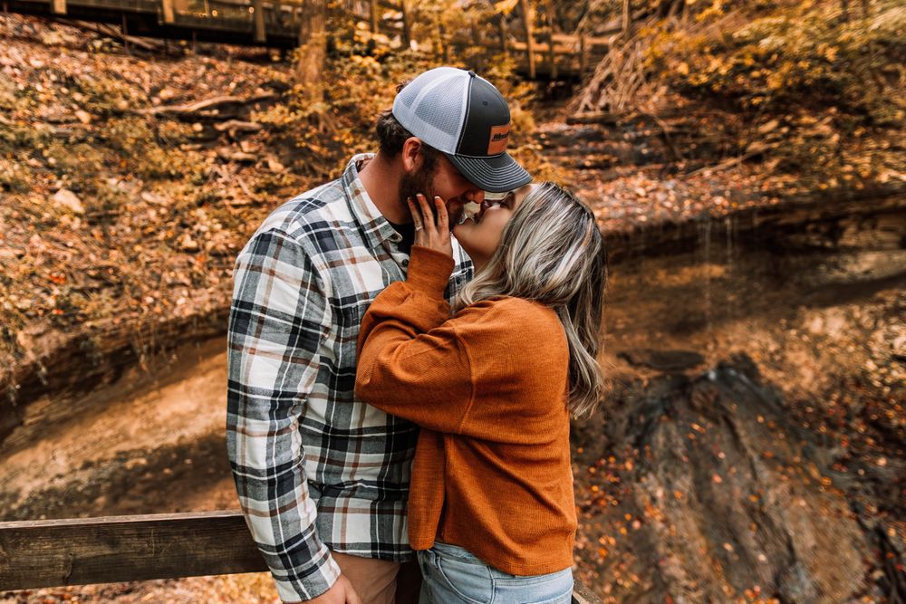 Woman grabs her fiance's face for a kiss at Pikes Peak State Park Bridal Veil Falls
