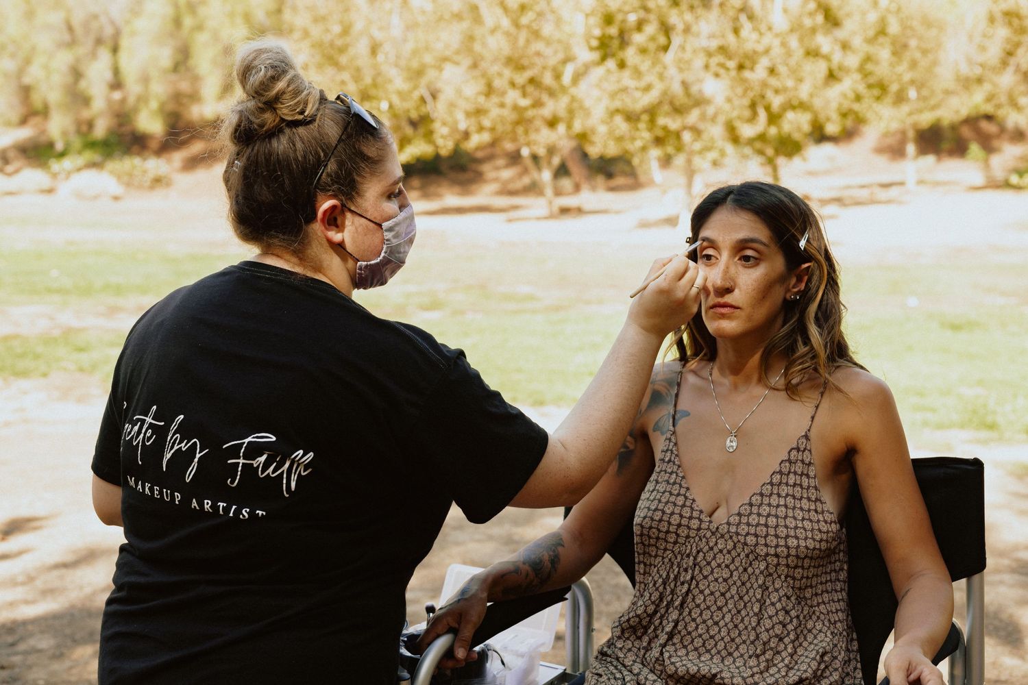 Behind the scenes makeup session during outdoor photoshoot.