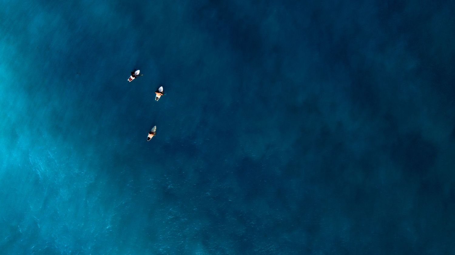 3 surfers standing by for a wave at Saint-Martin, shot from above with a Mavic Pro 2 drone.