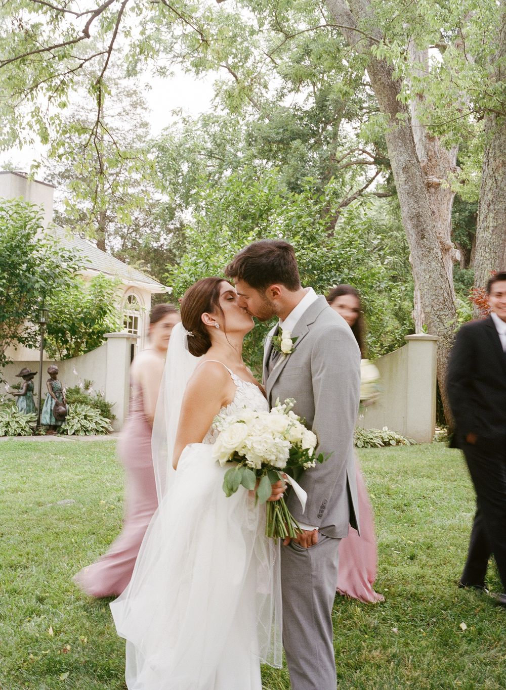 A tender moment between newlyweds in a garden setting with white flowers.