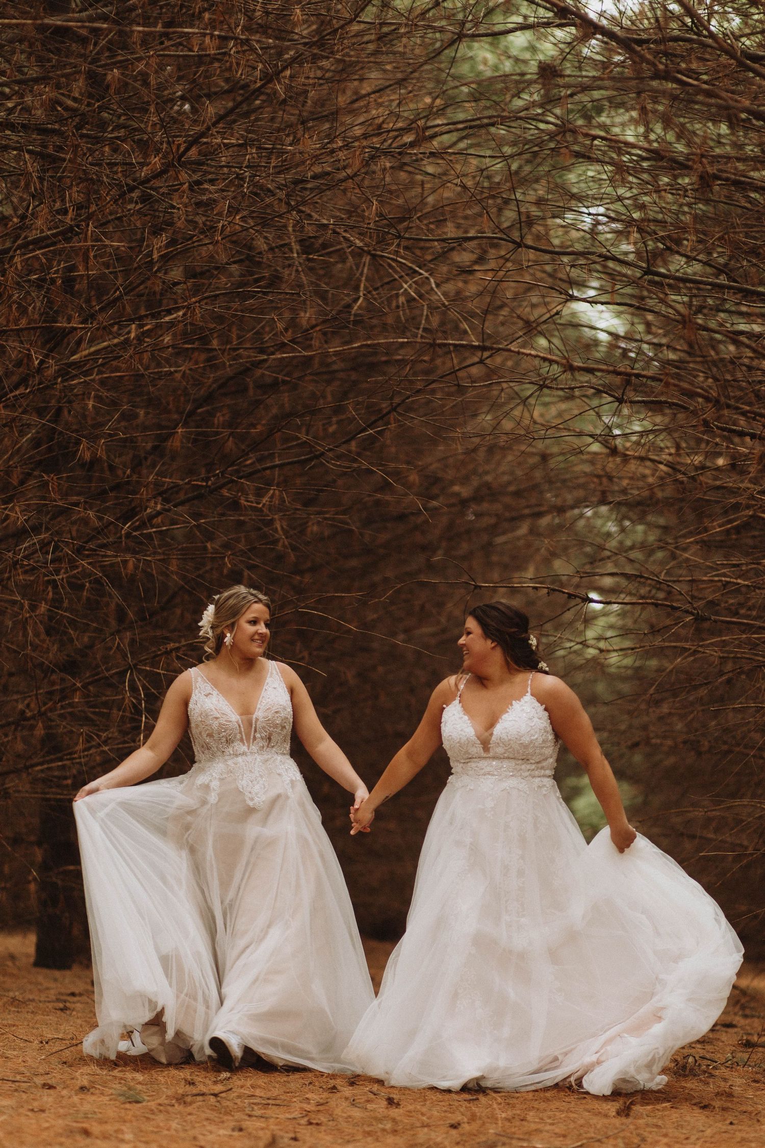 LGBTQ Wedding Couple walks through the pine trees at Maidenwood Weddings and Events.