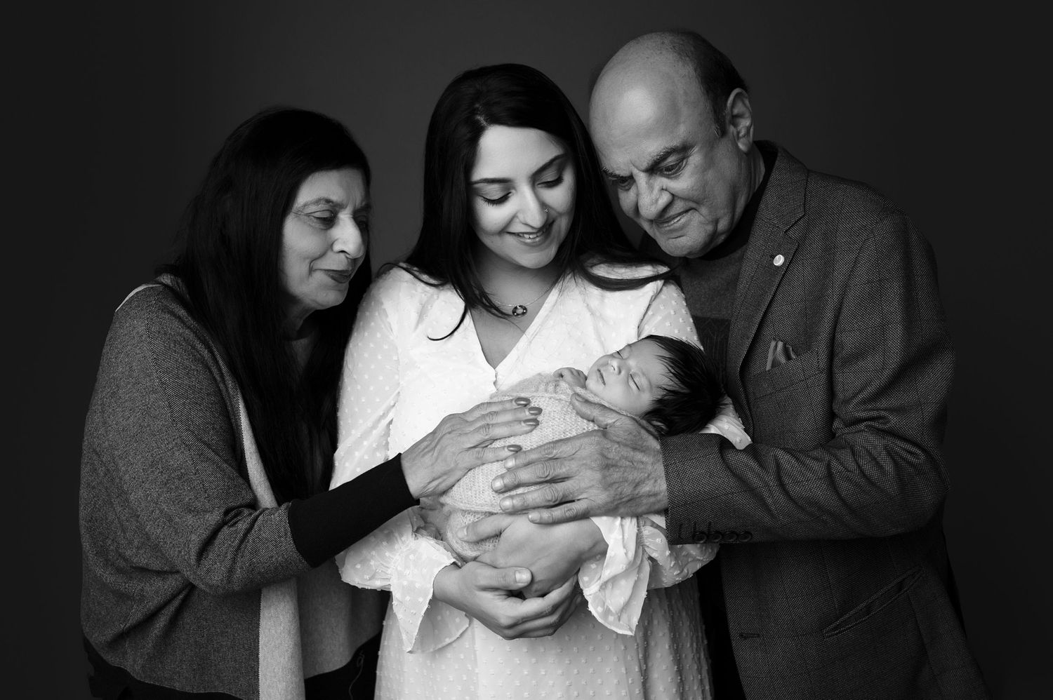 Black and white portrait of multi-generational family members sharing joy together.