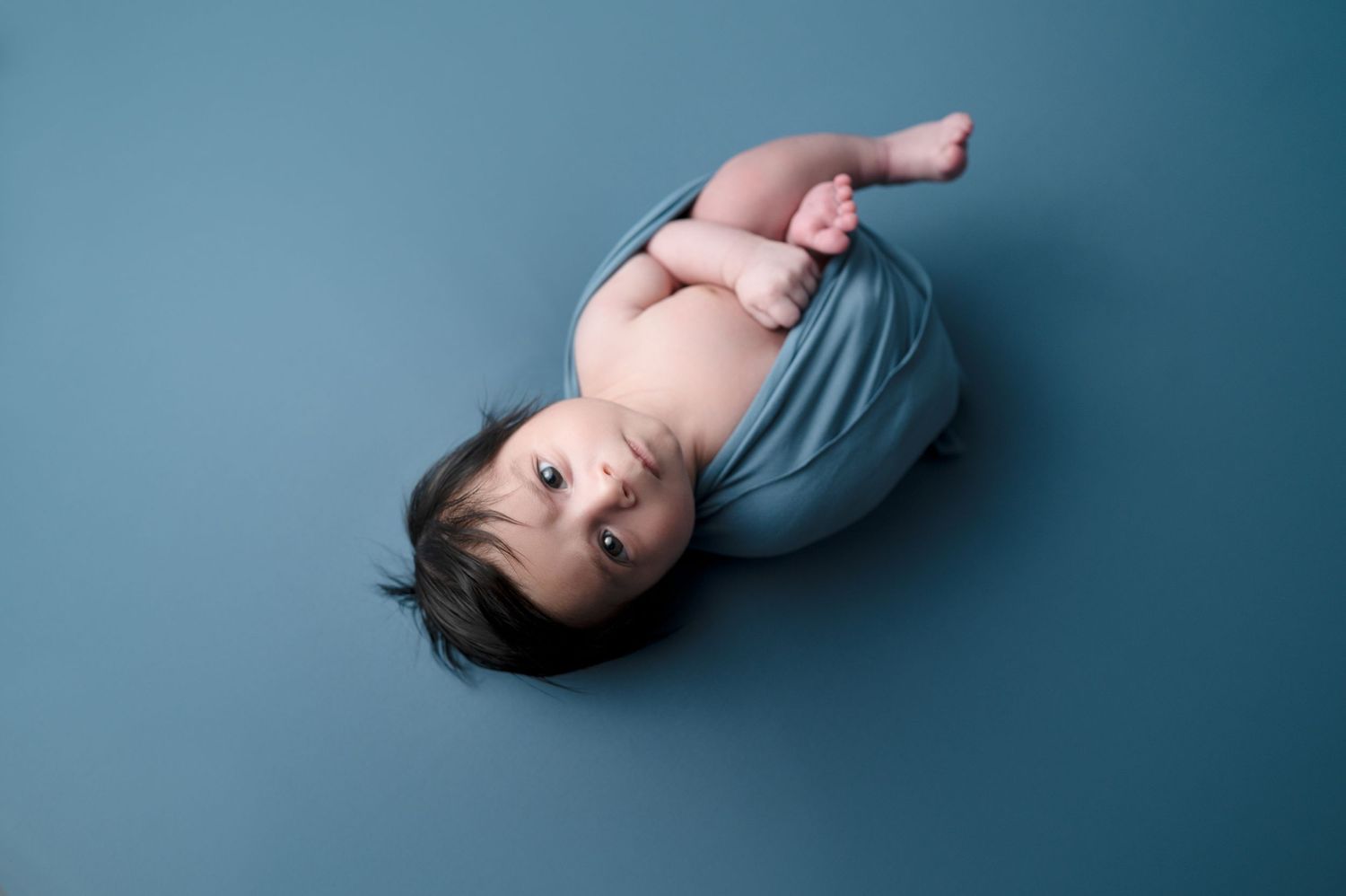 Artistic portrait capturing serene expressions against a soft blue background.