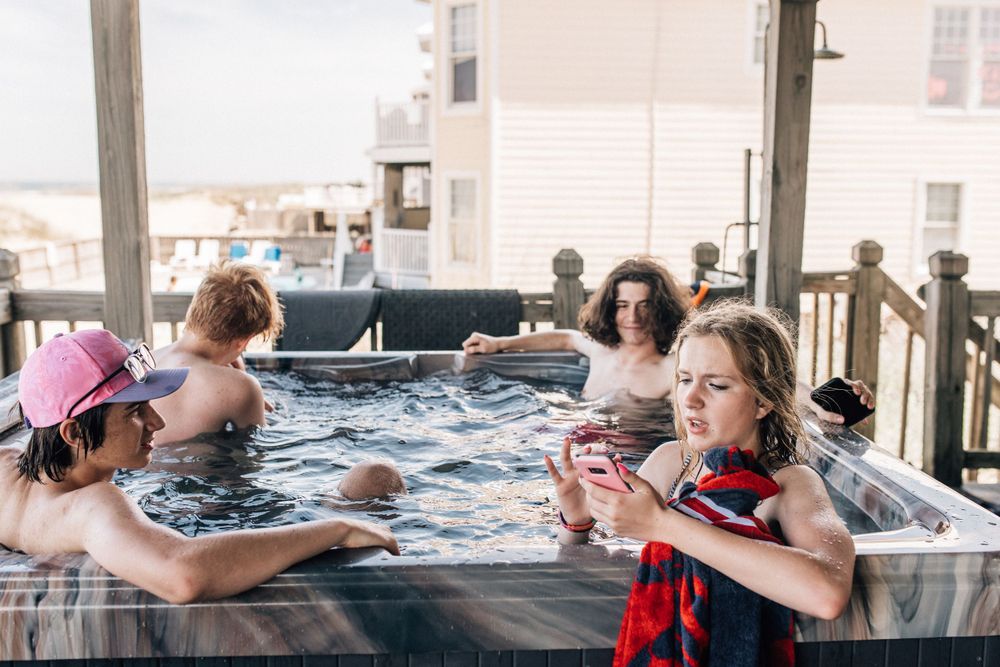 teens in a hot tub texting at vacation home in sandbridge beach, virginia