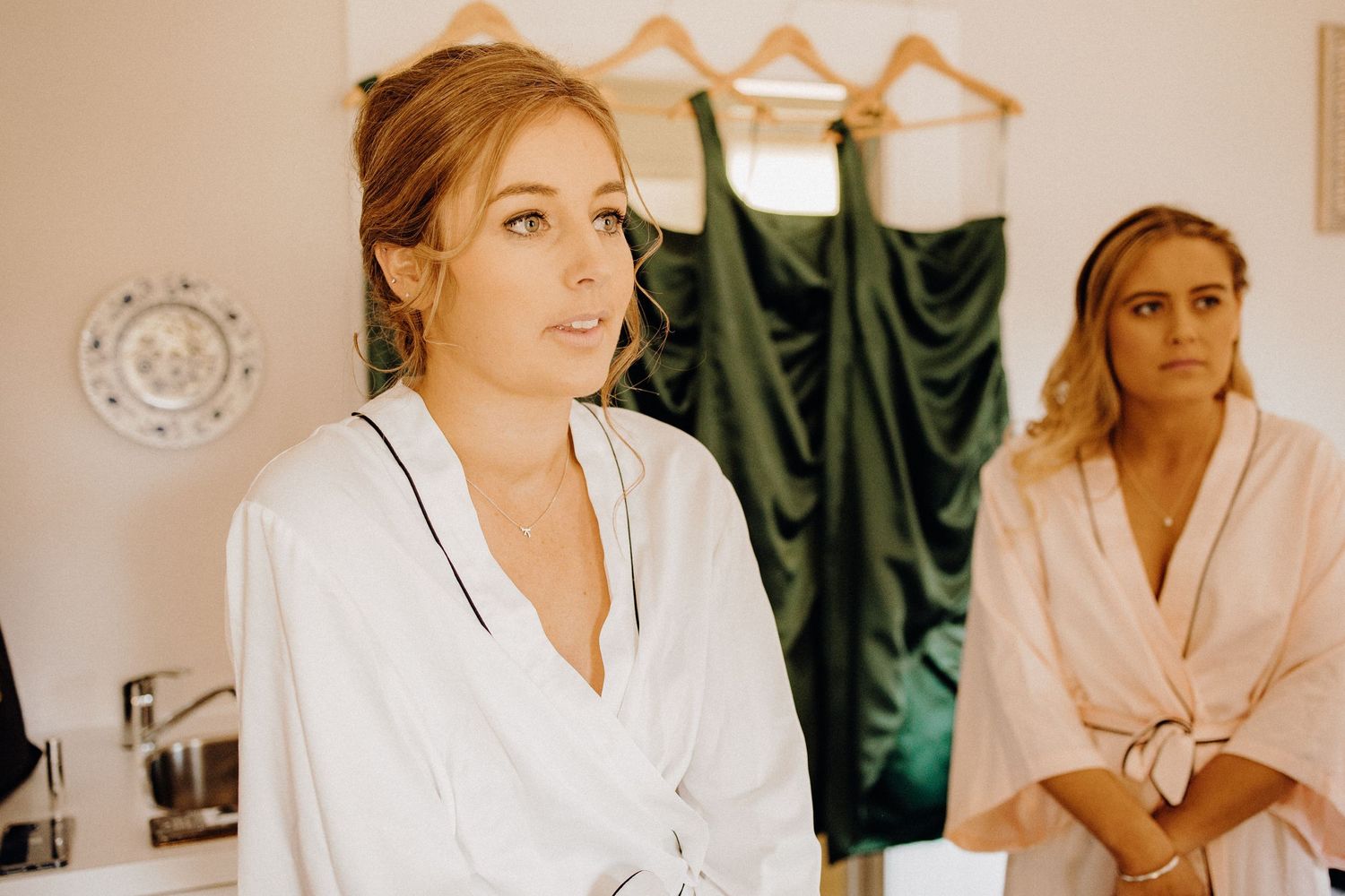 Getting ready scene with green bridesmaid dresses visible in background.