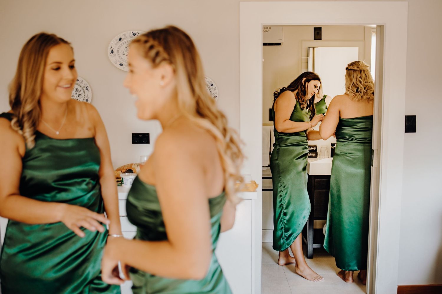 Two people in emerald green satin dresses interact in sequence of candid moments during a formal event.