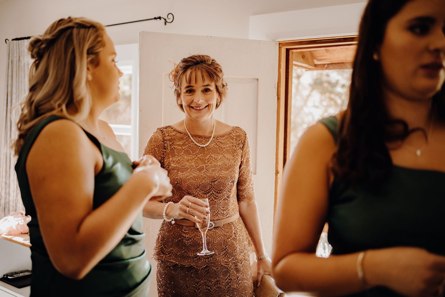 Wedding party members in various outfits including green dresses and formal attire prepare for the ceremony.