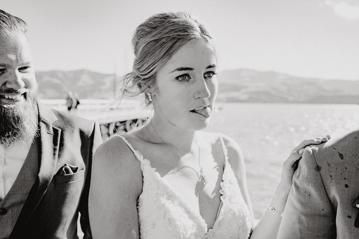 Natural black and white candid shots of wedding party members against scenic landscape.