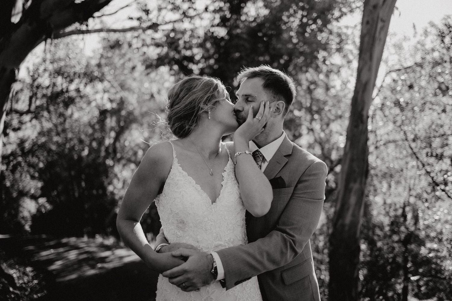 A romantic black and white moment captured between newlyweds in a garden setting.