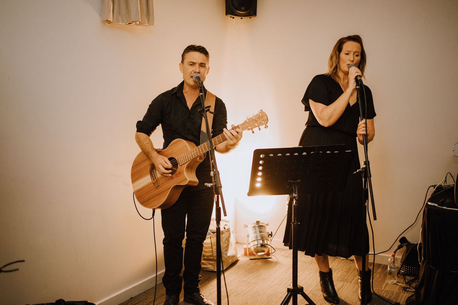 Live wedding band performers with guitarist and vocalist entertaining guests.