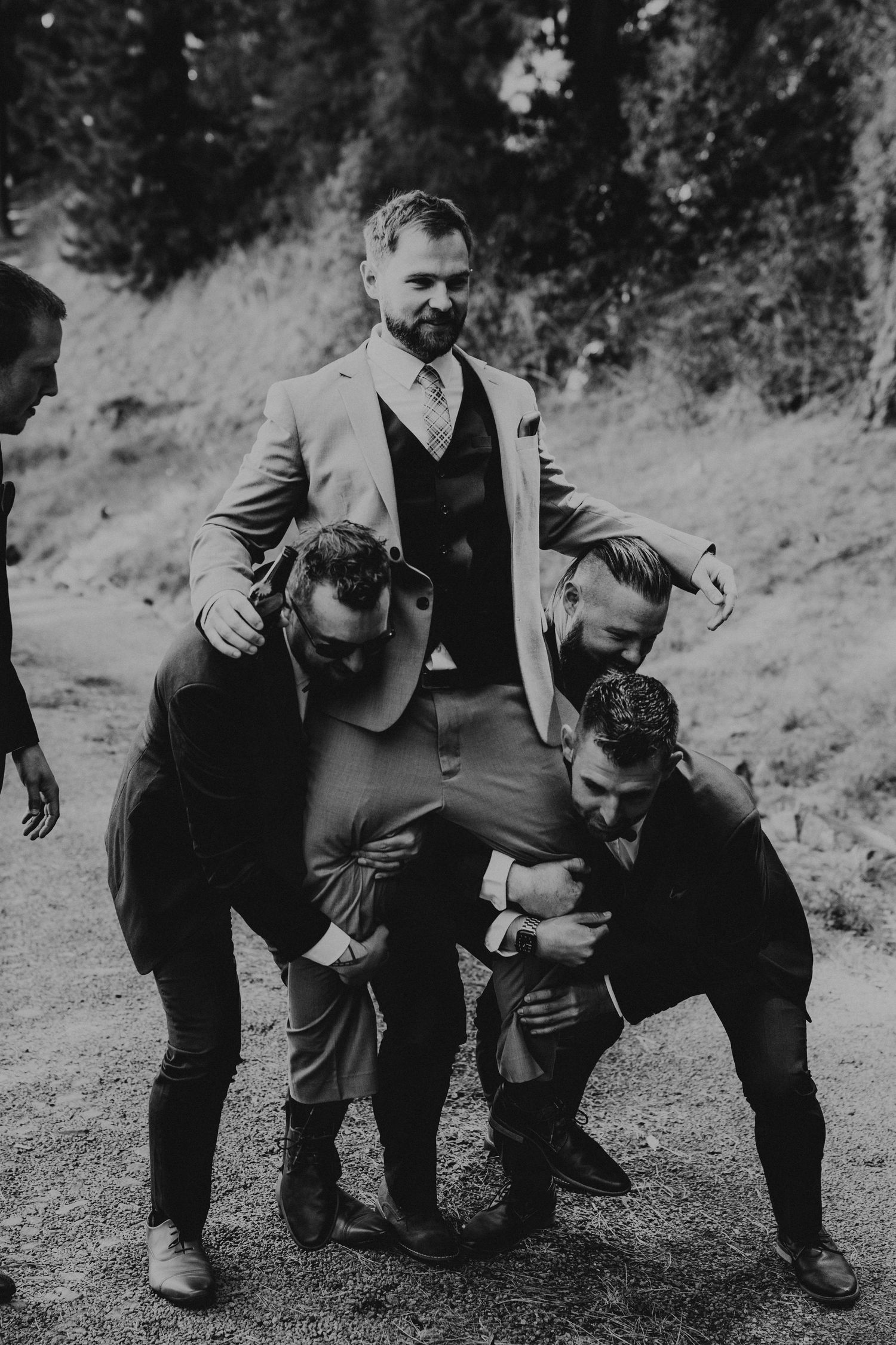 Black and white photos of groomsmen sharing lighthearted moments outdoors.